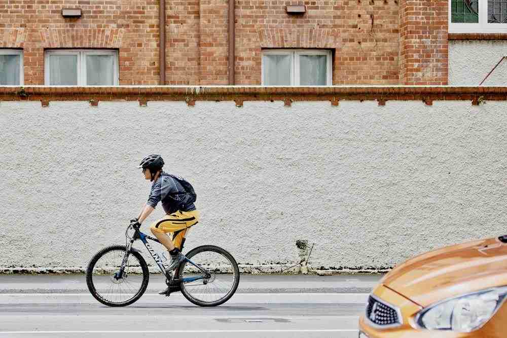 man riding black bike on street