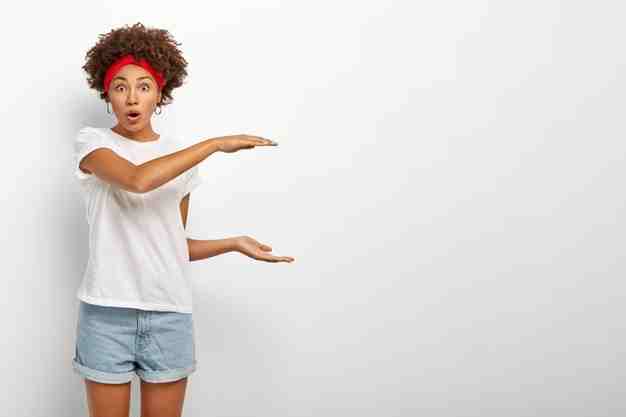 fascinated-ethnic-woman-explains-size-some-object-discusses-something-big-large-introduces-huge-object-with-surprisement-keeps-mouth-opened-dressed-casual-outfit-isolated-white-wall_273609-32264.jpg