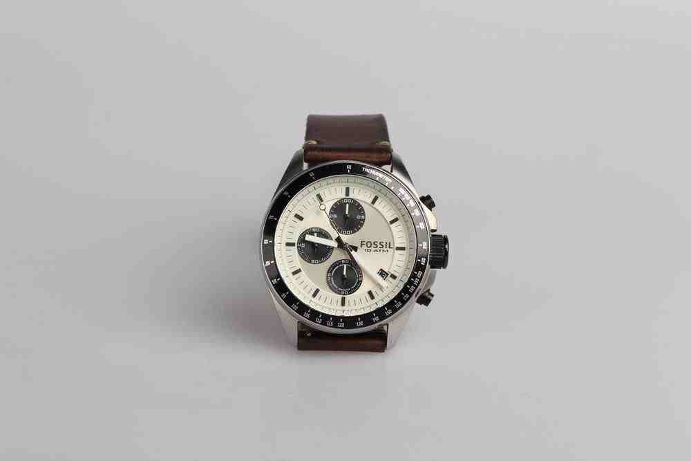 round silver-colored Fossil chronograph watch at 9:22 with brown leather band