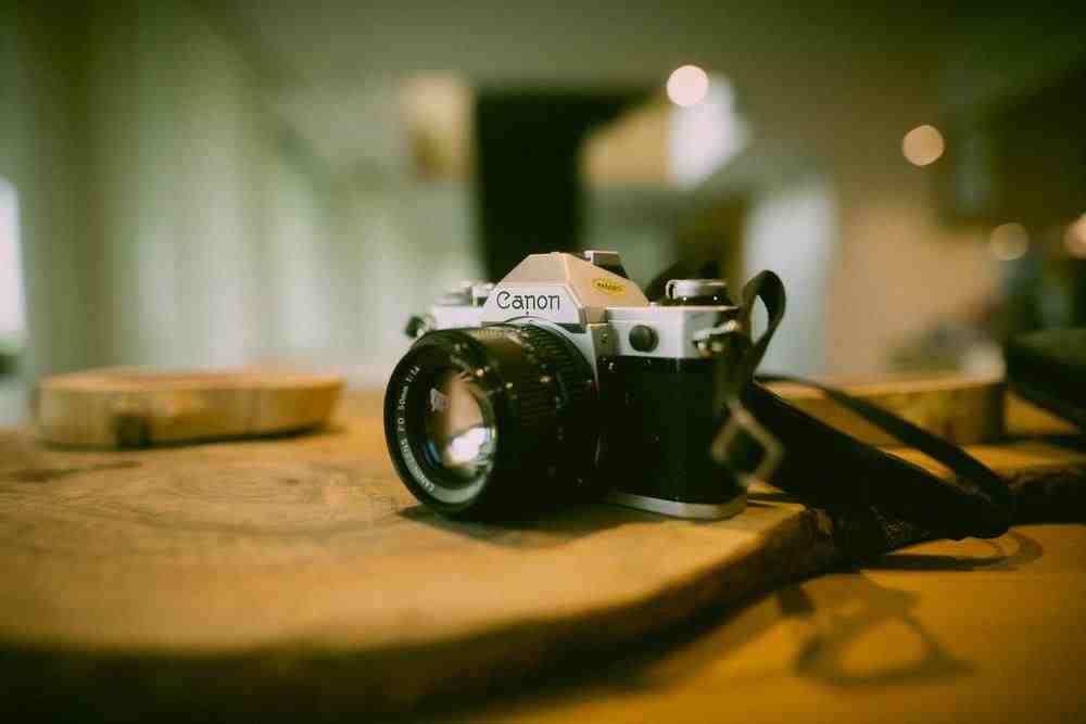 black and silver nikon dslr camera on brown wooden table