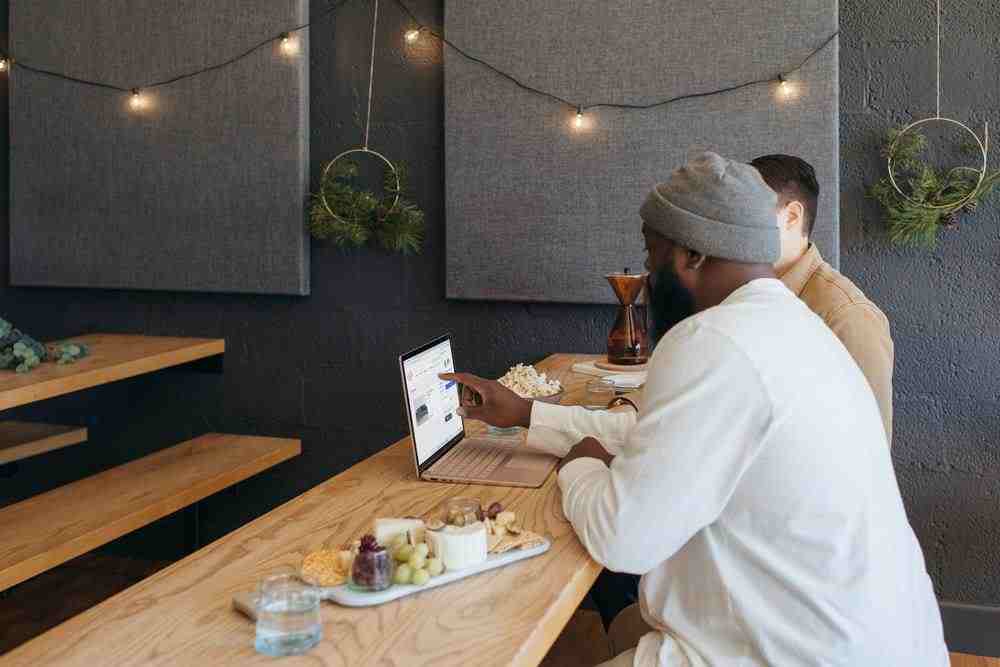 Two people collaborating on their Surface laptop sitting on a table at work 